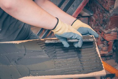 Çalışma kiremitçi tutkal kutunun üzerinde çentikli bir mala ile yapıştırma önce döşeme ve kaplama teknolojisi geçerlidir