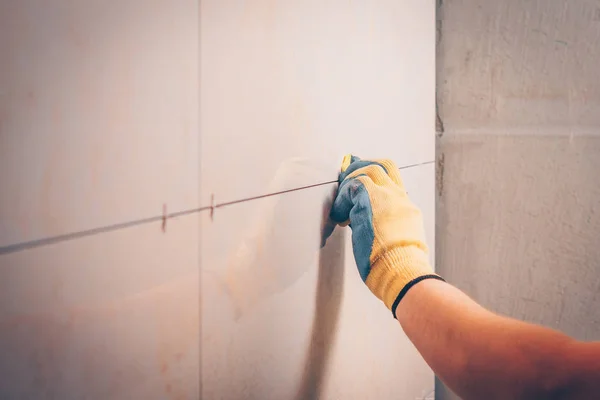 工作的老虎在墙上安装瓷砖 在交织缝合线插入一个塑料十字 瓷砖技术 — 图库照片