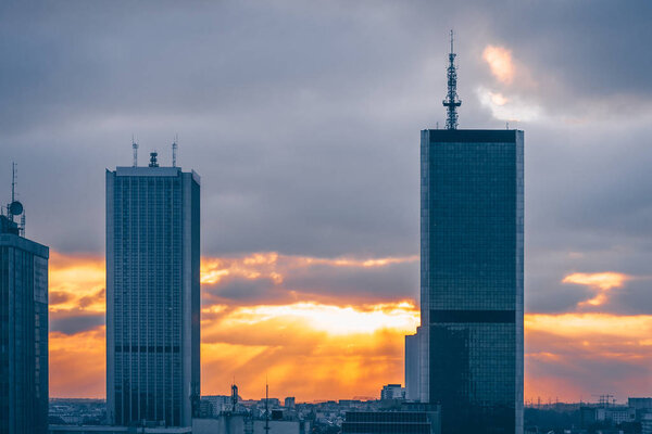 Modern high-rise buildings of glass and steel against the sunset