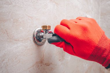 Adam ellerini su musluğuyla açar.