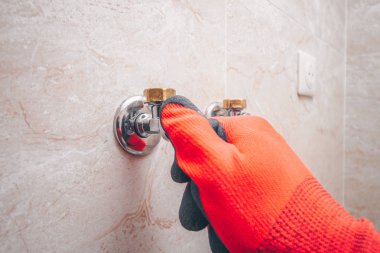 Adam ellerini su musluğuyla açar.