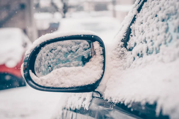 The arrival of spring in the cold snow-capped frosty countries, car mirrors under the snow