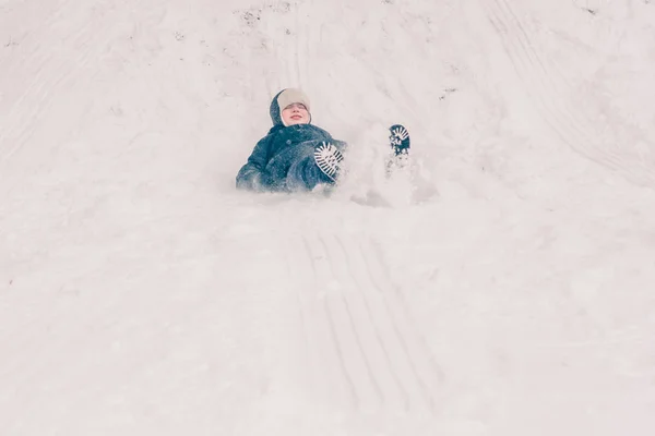 一个男孩骑在雪橇上 冬天的雪结冰了 — 图库照片