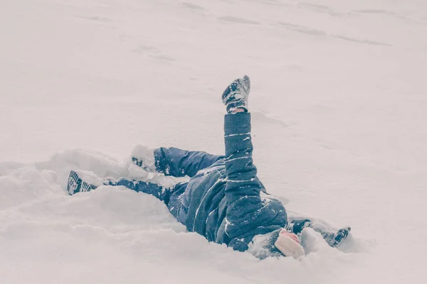 Niño Está Tirado Jugando Nieve Colina Invierno Nieve Helada Tiempo —  Fotos de Stock
