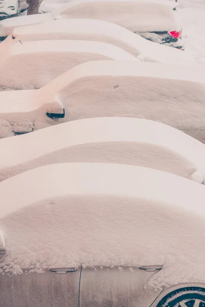 Standing in a row of snow-covered cars, cars are blocked in the snow as a result of cyclone actions