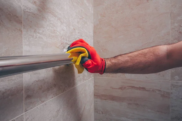 A man in gloves wipes a new towel warmer, cleaning works