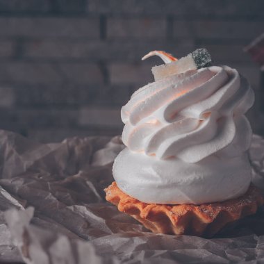 Yakın çekim paketinde beyaz krema ve beze ile Cupcake, seçici odak, trend tonlama, kare format