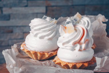 Yakın çekim ambalaj, seçici odak, trend tonlama, kare formatta beyaz krem ve beze ile üç cupcakes