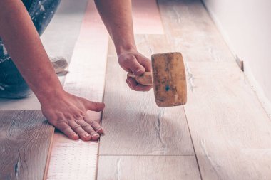 Bir çekiçle çalışmak, kaplamayı tıkar, döşemeyi profesyonelce döşemek, lamine etmek...