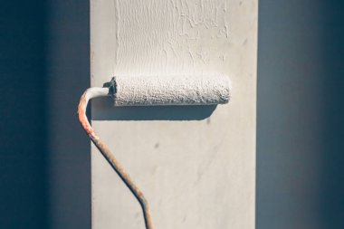 Beyaz boya ile bir kürk silindir yakın çekim bir pencere eğim boyar