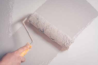 Ressam bir kürk rulo ile duvarı boyar, bir arka plan, bir arka plan