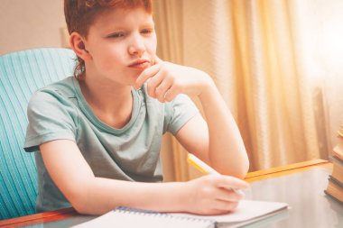 Kırmızı saçlı çocuk ödev yapma görevini düşündü, sert mücadele tren kolay