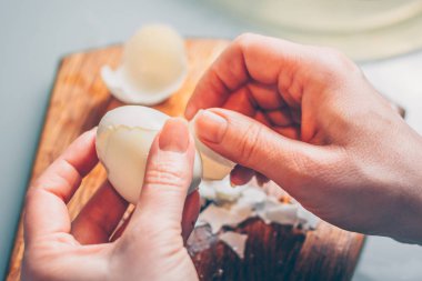 Bir kadın kabuk bir haşlanmış yumurta temizler, bir birinci şahıs görünümü