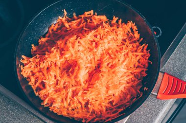 Aşçı kızartma tavasında havuç kızartır