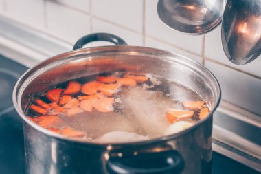 Soba üzerinde bir tencerede Cook aşçılar suyu