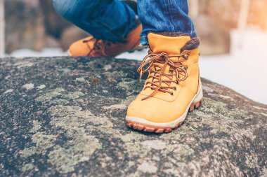 Kaya üzerinde dağlarda yürüyüş çizmeler içinde keşfeden ve gezgin bacaklar