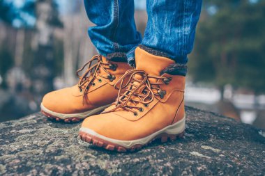 Kaya üzerinde dağlarda yürüyüş çizmeler içinde keşfeden ve gezgin bacaklar