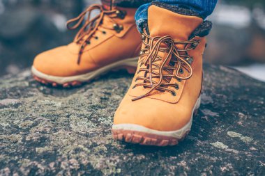 Kaya üzerinde dağlarda yürüyüş çizmeler içinde keşfeden ve gezgin bacaklar