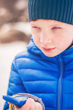 Elinde bir pusula ile Kızıl saçlı çocuk, macera arayışı içinde ormanda hareket yönünü seçer