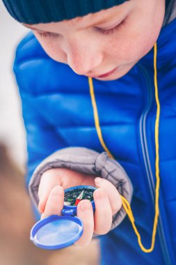 Elinde bir pusula ile Kızıl saçlı çocuk ormanda hareket yönünü seçer