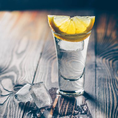 Kireç, nane ve buz dilimleri bir dilim ile ahşap bir masada bir cam soğuk tekila