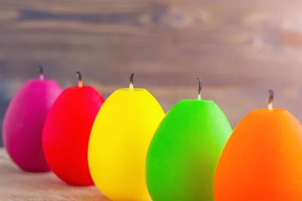 A row of colored candles in the shape of an egg, an easter still life