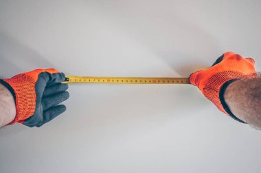 Birinci şahıs görünümü: bir bant ile eldiven önlemler işçi duvar genişliği ölçmek