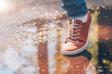 Yavaşça deri ayakkabılarında su birikintisi üstesinden gelir