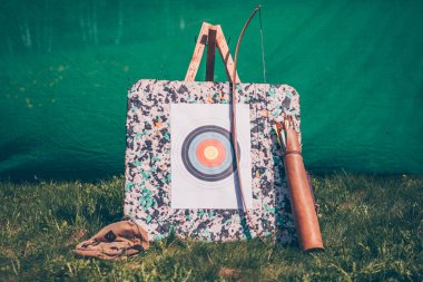 Atış eğitimi için yeşil çim üzerinde oklar ile hedef, yay ve titreme