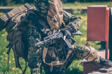 Tam teçhizatlı asker taş duvarı aştı.