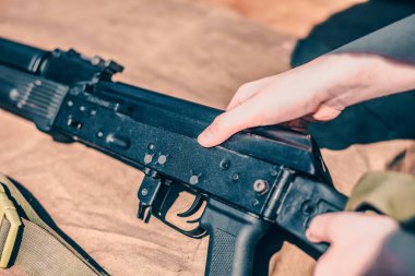 Çocuk ak-47 Kalaşnikof demontaj yürüten alıcının kapağını kaldırır
