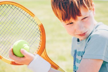 Genç Kızıl saçlı tenis oyuncusu topu hazırlamakla yoğunlaşıyor