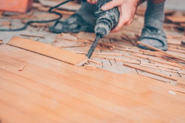 Bir matkap zımba ile çalışma parke zemin kırar