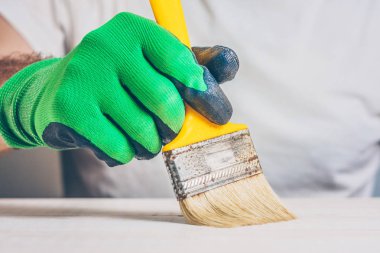 Ressam, yüzeyde vernik ile boya fırçalamayı gerçekleştirir