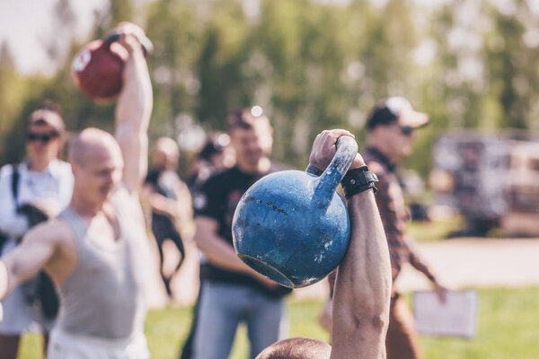 Minsk, Belarus, May 05, 2018: Group exercise with kettlebell lifting in the open air. Festival of a healthy way of life