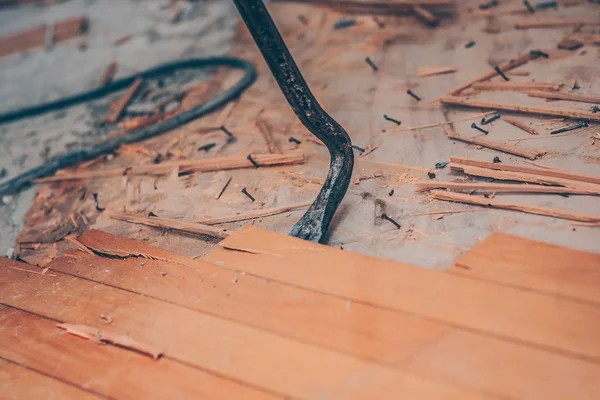 Worker with a nail mount fixes the parquet floor