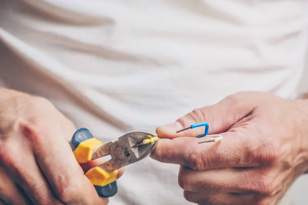 The electrician performs electrical work on the cutting of the electrical cable