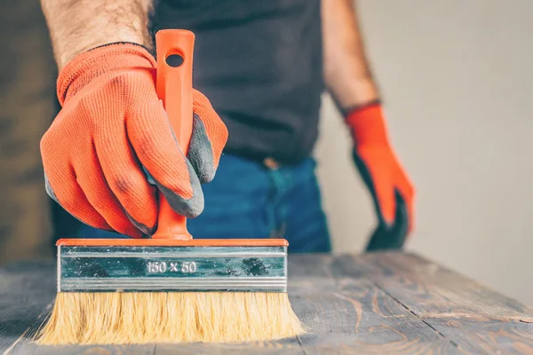 Bir fırça ile ahşap bir yüzey üzerinde sıvı balmumu uygulaması