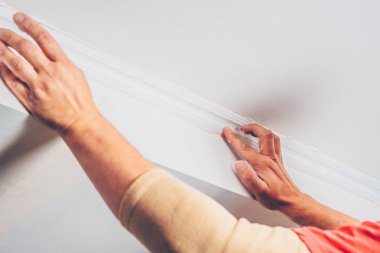 iş bitirme-işçi bir dekoratif tavan Kaide yapıştırır