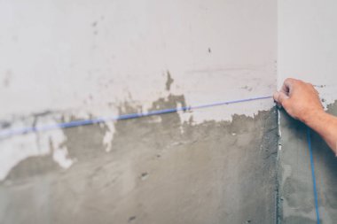 iş bitirme-işçi duvarda fayans için bir işaretleme yapar