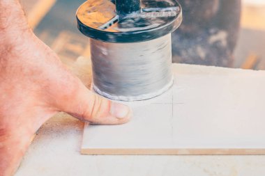 Bitirme işleri-işçi bir tornavida ve bir elmas bit ile elektrikçiler montaj için fayans yuvarlak bir delik keser