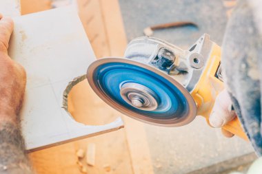 Bitirme işleri-kirişler bir açı değirmeni ile fayans yuvarlak bir delik keser