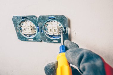 Bitirme işleri-birinci şahıs görünümü-bir elektrikçi duvar prizinin vidalarını