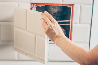 Kız tıkanma ve Temizleme ortadan kaldırmak için kanalizasyon borusunun muayene deliğe erişmek için fayans duvarında gizli bir ambar açar