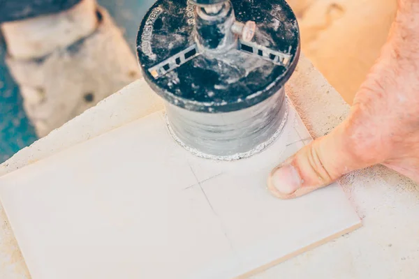 精加工 工人在瓷砖上切割一个圆孔 用于安装电工 — 图库照片