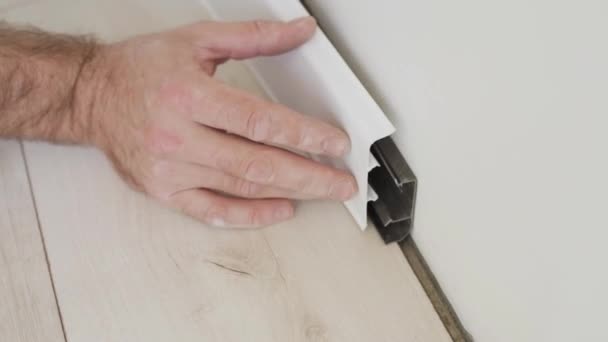 Afwerking Thuis Meester Mounts Installeert Baseboard Aan Muur — Stockvideo