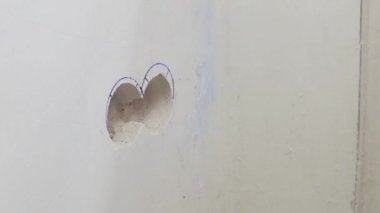 Elektrikçi elektrik işi gerçekleştirir-beton duvardaki bitmiş deliğe plastik bir kutu yükler