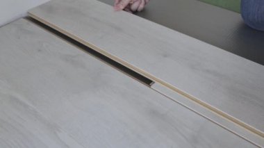 Bir işçi, keçeli kalem ve kareyle kaplama panelinde budamak için bir etiket hazırlar.