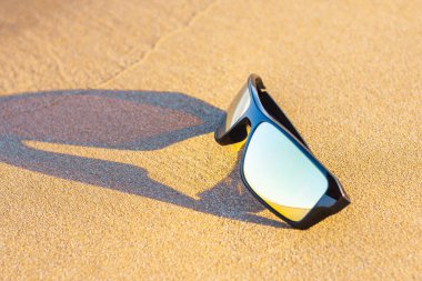 tropikal bir plajın kum üzerinde akşam güneş gözlüğü