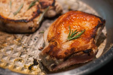 Bir tavada gevrek bir kabuk ile domuz filetosu kavrulmuş ruddy parça